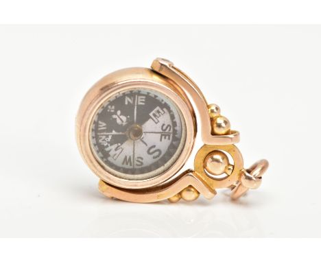 AN EDWARDIAN 15CT GOLD SWIVEL COMPASS AND CARNELIAN FOB, a circular spinning fob with a mother of pearl compass and carnelian