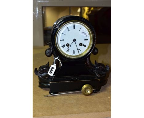 A VICTORIAN EBONISED MANTEL CLOCK, the balloon shaped case flanked to each side by carved dolphins, one with losses to tail f