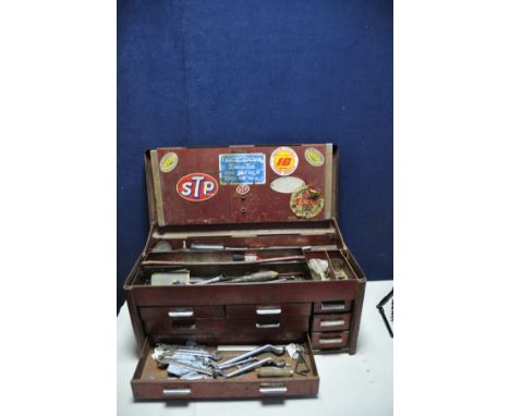 A METAL BENCH TOP TOOLBOX with seven draws and folding open top containing some tools to include spanners, drivers etc