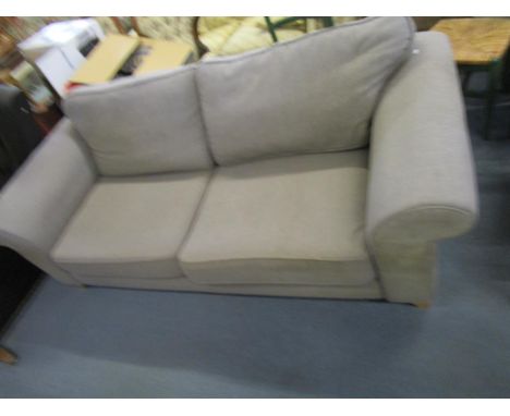 A large grey upholstered two seater sofa on light wood block feet 