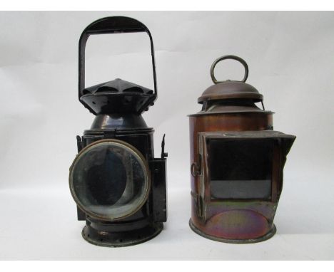 A black painted metal railway lamp with a rotating handle, operating a red or blue glass panel, flanked by side clips, 12 1/2