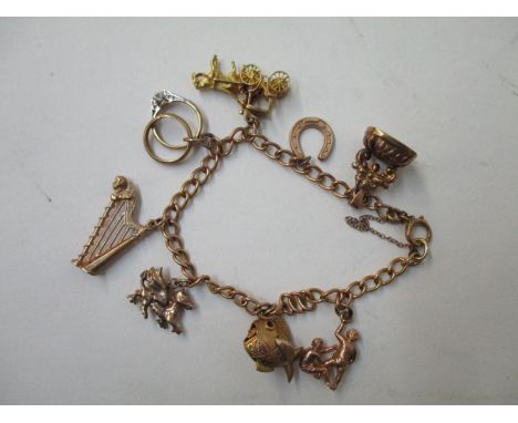 A 9ct gold bracelet with nine charms and a miniature ring set with a past stone, 25g 