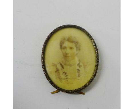 Oval portrait miniature on ivorine plaque contained within a brass frame with easel strut back, 8.5 x 7cm