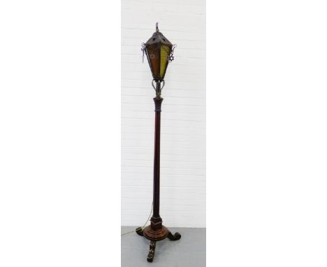 A brass and mahogany standard lamp with lantern shade with frosted glass, on reeded column and turned base with scroll feet, 