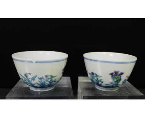 A pair of Chinese Wucai teabowls painted with flowers and foliage to a white ground with blue double line borders, bearing si