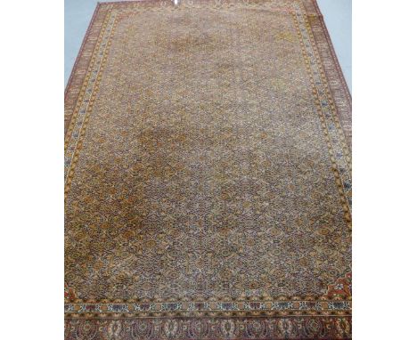 A large carpet, the red field with all over medallion pattern within a palmette border, 405 x 275cm