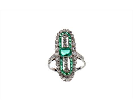 EMERALD AND DIAMOND RING, the central step cut emerald flanked by three collet set diamond, within a border of calibre cut em