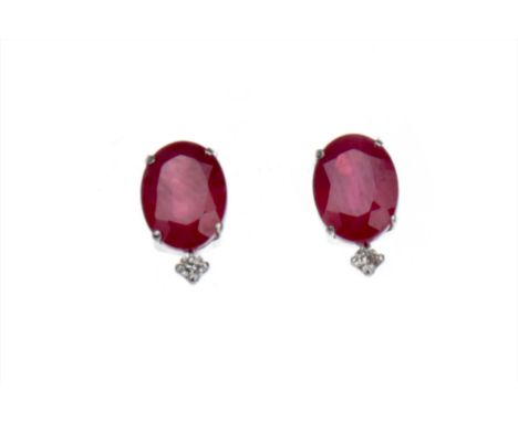 PAIR OF TREATED RUBY AND DIAMOND EARRINGS, each set with an oval faceted treated ruby and a round brilliant cut diamonds, the