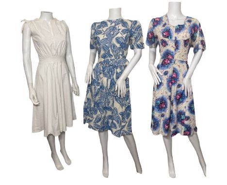 1950s volup rose print dress, a blue and white abstract orchid print dress with pockets, puffed shoulders and a wide belt, an