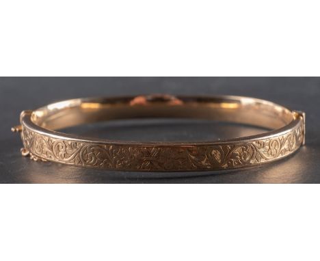 A 1940's, 9ct gold hinged bangle, decorated with foliate engraving, inner diameter ca. 6cm, total weight ca. 8gms.