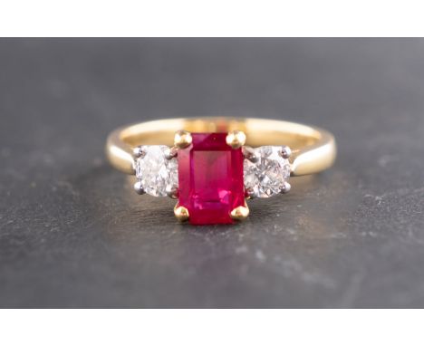 An 18ct gold, octagonal, step-cut synthetic ruby and round, brilliant-cut diamond three-stone ring, total estimated diamond w