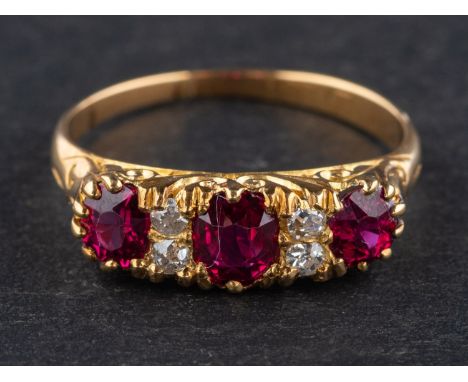 An 18ct gold, oval, mixed-cut ruby ring, with single-cut diamond spacers, total estimated ruby weight ca. 1.05cts, with parti