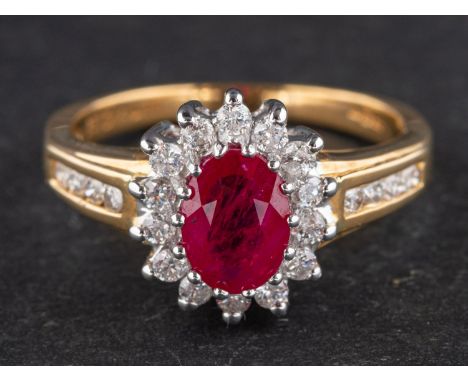 An 18ct gold, oval, mixed-cut synthetic ruby and diamond cluster ring, total diamond weight ca. 0.33ct, according to stamp, l