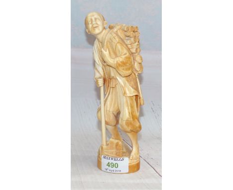 A late 19th century Japanese okimono figure of a woodcutter with axe and logs on his back, red seal mark to base, height 8"