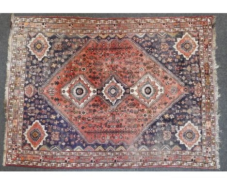 A hand knotted Persian Hamadan carpet, the red and blue fields with repeating floral roundels, within a triple border