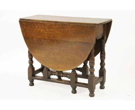 A 19th century oak gate leg table, having twin oval flaps on stretchered turned supports, 133cm wide, 90cm deep, 74cm high