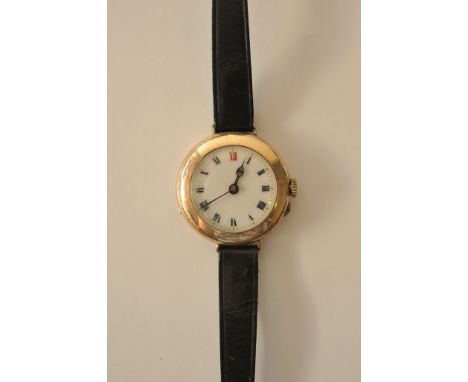 A 1920s ladies gold plated wristwatch with white enamel dial, Roman numerals and black leather strap