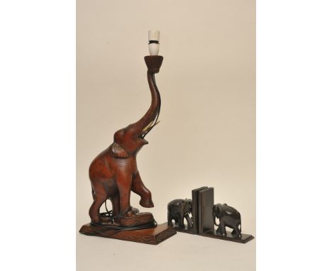 A carved hardwood elephant lamp and a pair of carved hardwood bookend 