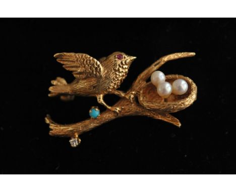 A fine quality gold brooch in for form of a branch with a birds nest set with three seed pearl eggs and songbird set with fur