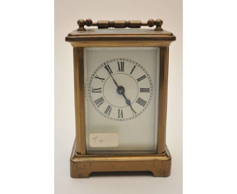 A brass cased carriage clock with bevelled edge glass and visible escapement
