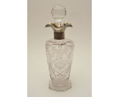 A glass decanter with silver collar 