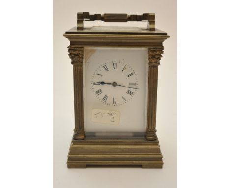 A brass cased carriage clock with bevelled edge glass and pillar supports