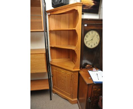 An Ercol pitch pine corner display unit with open shelves above a cupboard 