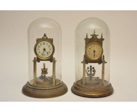 Two brass anniversary clocks under glass domes, one with enamel dial