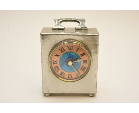 A small hammered pewter clock by Liberty & Co. with blue enamel dial and copper chapter ring (later movement fitted, original