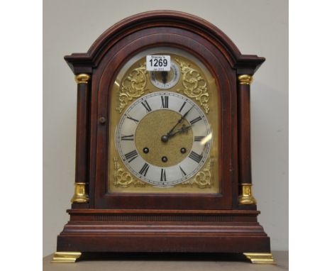 A Gustave Becker mahogany mantle clock having arched Roman numeral dial with key and pendulum