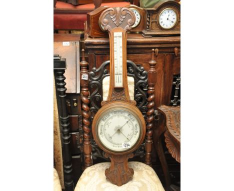 An oak wall barometer with a carved scroll top 
