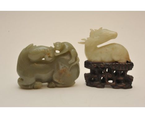 A Chinese jade carving in the form of a stag on a hardwood base together with one other in the form of a recumbent horse with