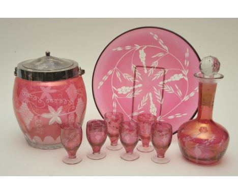 A collection of cut cranberry glass comprising a decanter and six glass on tray, and a biscuit barrel with silver plated lid 
