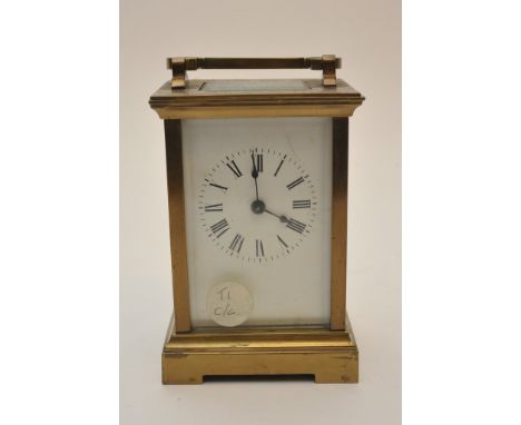 A brass cased carriage clock with bevelled glass and visible escapement