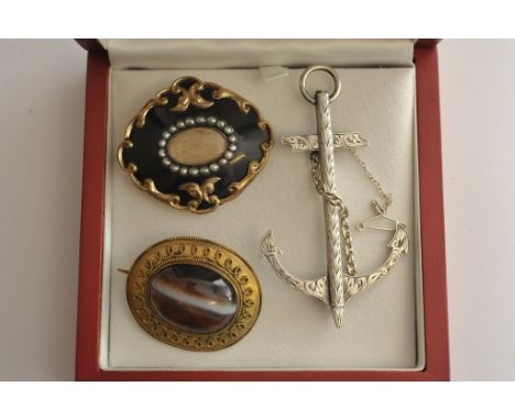 A collection of three Victorian brooches comprising silver anchor, enamel and seed pearl mourning brooch and one other