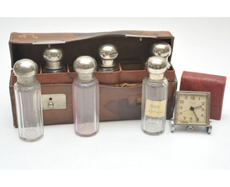 A Mappin & Webb chrome 8 day travelling clock, and six bottles in a leather case. (2)