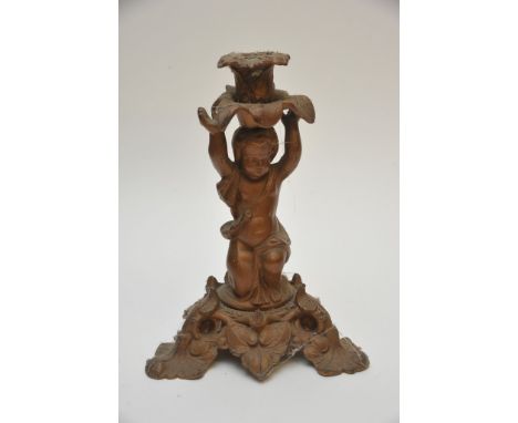 A gold painted spelter candlestick in the form of an ornate cherub