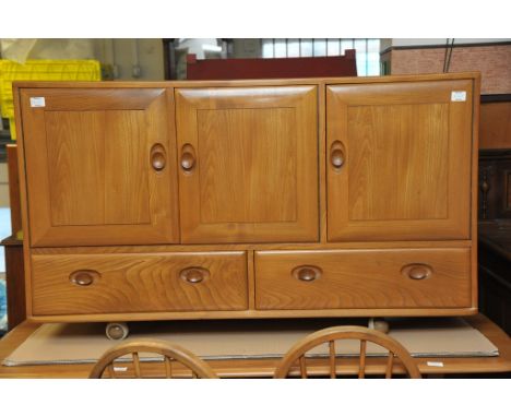 A Ercol table with matching sideboard and four stick back chairs