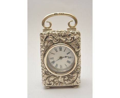 A quality small silver cased carriage clock with profusely repousse decoration and London hallmarks housing a French movement