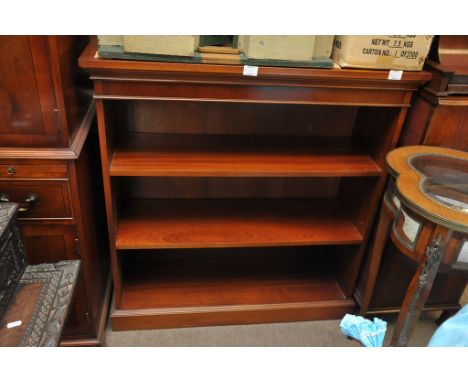 A mahogany open book case on bracket feet