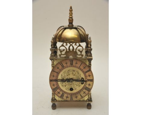 A brass cased key wind lantern style clock