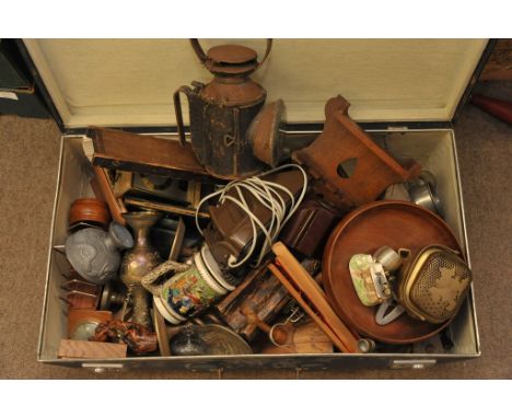 A suitcase containing an interesting collection of items including treen, a barometer, oil lamp and various metalware