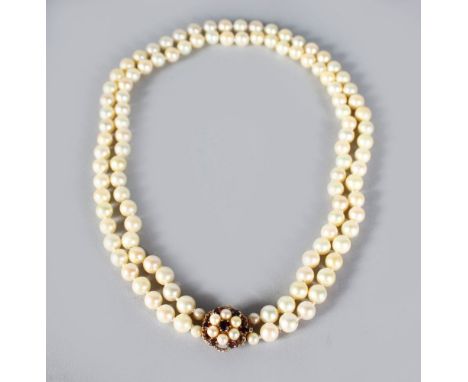 A TWO ROW PEARL NECKLACE with gold, amethyst and pearl clasp.