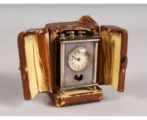 A MINIATURE BREVET NICKEL CLOCK, 2ins high, in a folding leather case.