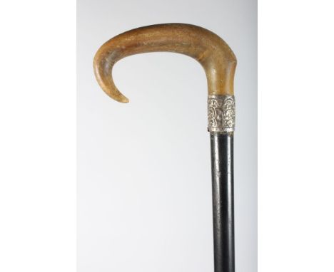 A POSSIBLY RHINO HORN HANDLE WALKING STICK with silver band.