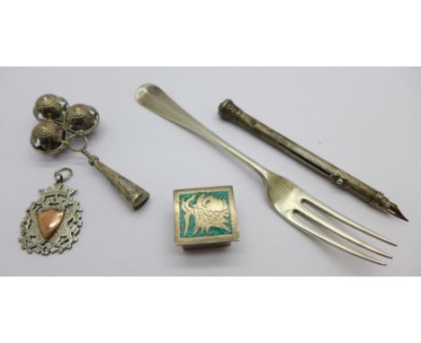 A silver fob medal, a Victorian silver fork, a sterling silver rattle, a pill box and a dip pen/pencil