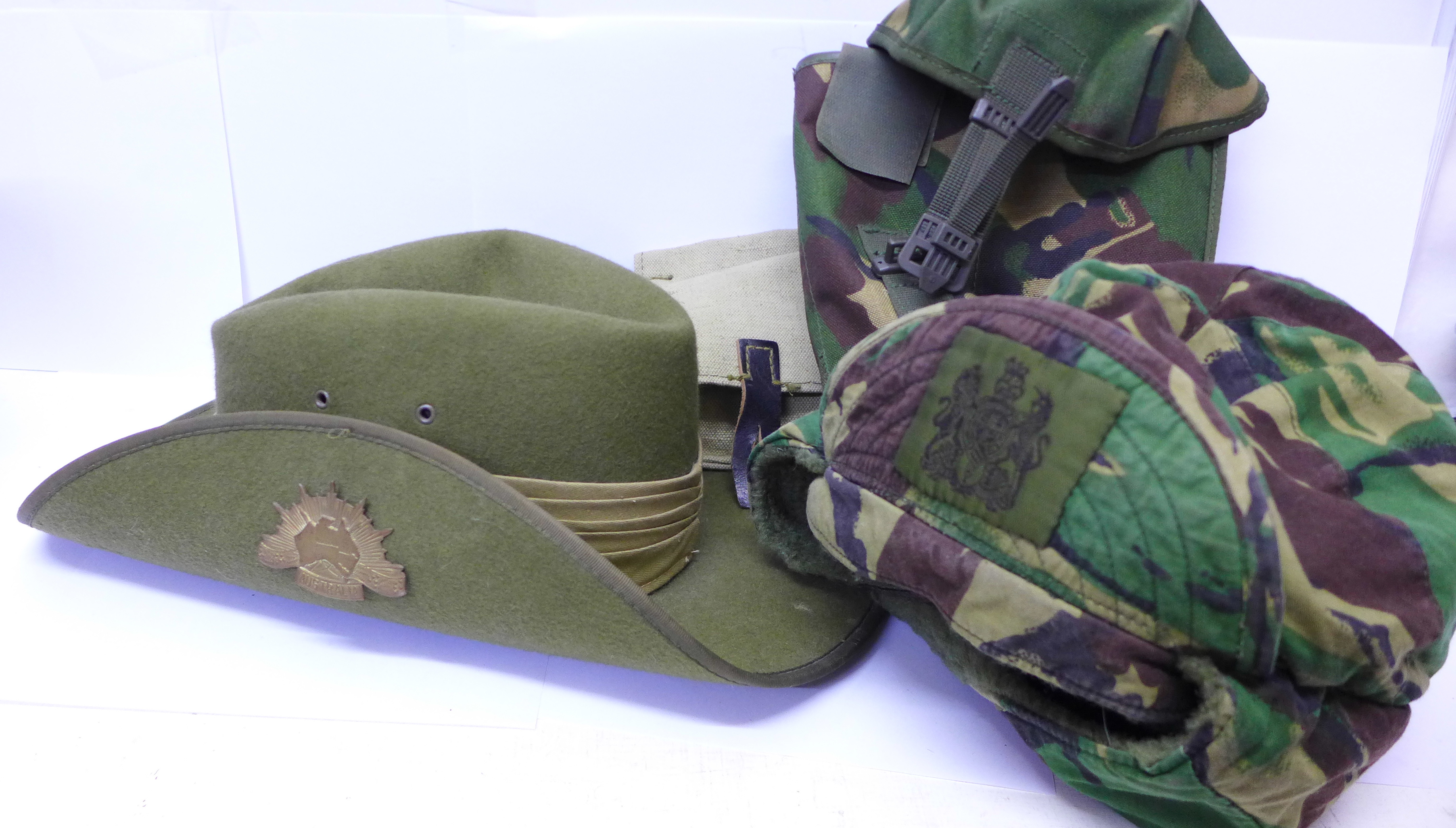 An Australian military style hat, one other camouflage hat and two