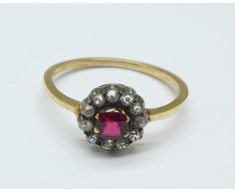 A Victorian cluster ring with silver settings, set with red and white stones (tests as gold), R