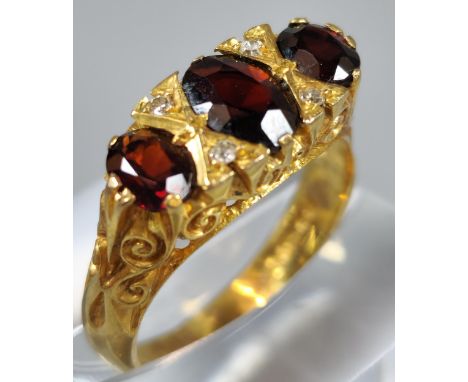 9ct gold three stone garnet and diamond dress ring. 4.3g approx. Ring size O 1/2. (B.P. 21% + VAT)