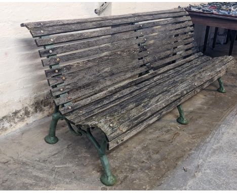 Slatted wooden garden bench with three part cast iron underframe. 182cm wide approx. (B.P. 21% + VAT)